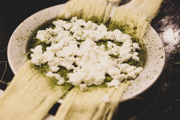 Dessert turc kunefe, kunafa, kadayif avec de la poudre de pistache et du fromage chaud mangé un bonbon