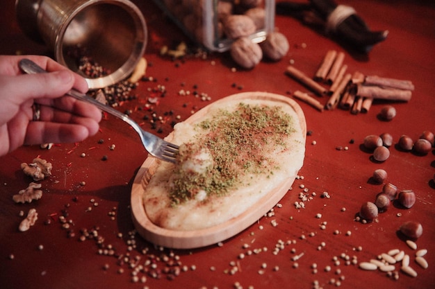 Dessert turc kunefe kunafa kadayif avec de la poudre de pistache et du fromage chaud mangé un bonbon