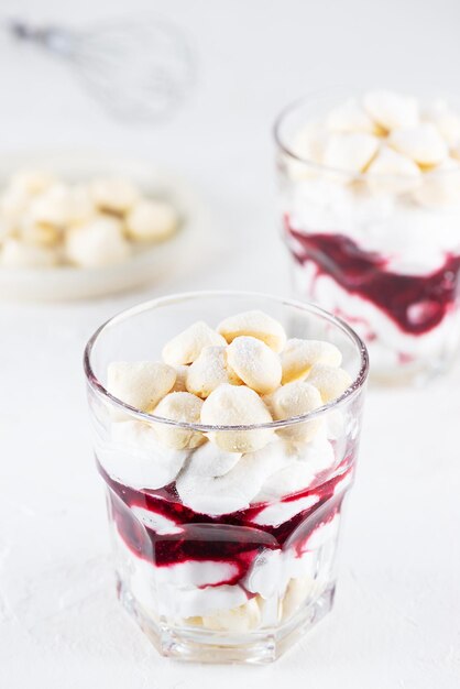 Dessert végétalien fait maison avec crème de noix de coco meringuée et cerises dans des verres