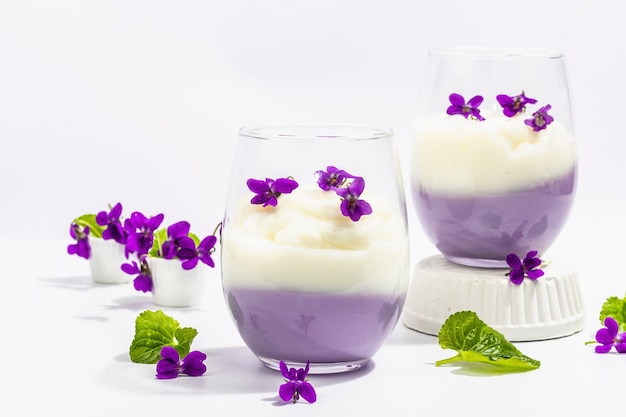 Dessert végétalien à la panna cotta avec fleur de violette fraîche