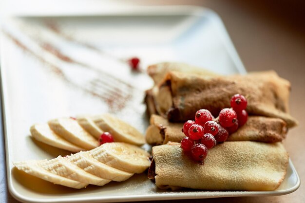 Dessertcrêpes chaudes à la pâte à tartiner au chocolat et banane Décorées de groseillesDessert sucré