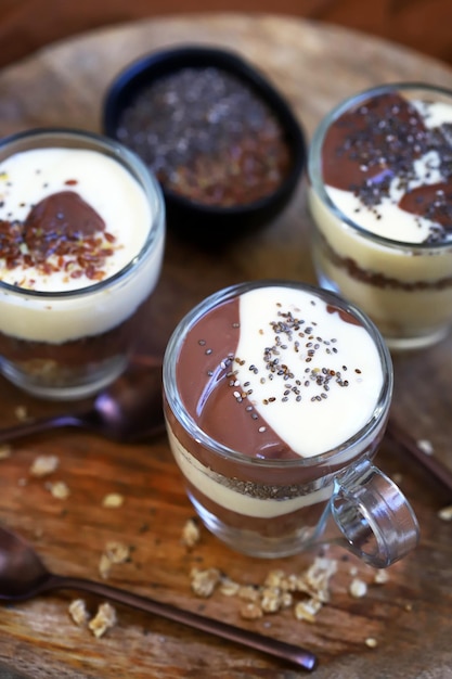 Desserts sains dans des tasses Puddings à la vanille et au chocolat avec graines de chia et graines de lin