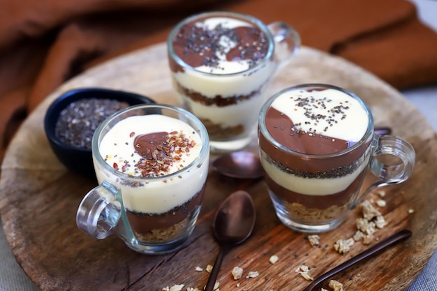 Desserts sains dans des tasses Puddings à la vanille et au chocolat avec graines de chia et graines de lin