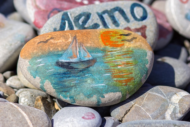 Photo le dessin à l'aquarelle peint sur une pierre de plage