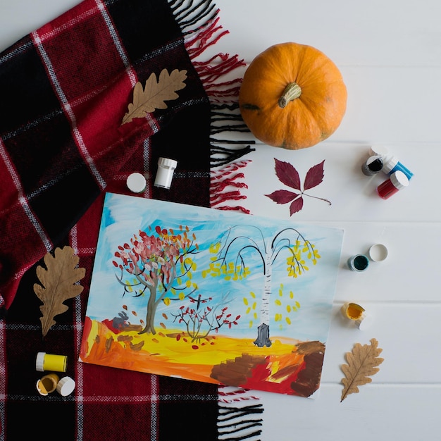 Dessin d'automne pour enfants avec des peintures sur la table, vue de dessus.