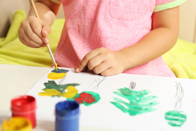 Dessin d'enfant avec des peintures lumineuses sur papier gros plan