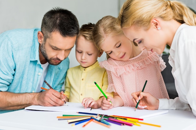 dessin de famille heureuse avec des crayons de couleur ensemble à la maison