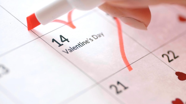 Dessin à la main coeur rouge avec marqueur autour de la date du 14 février sur la feuille de calendrier Saint Valentin