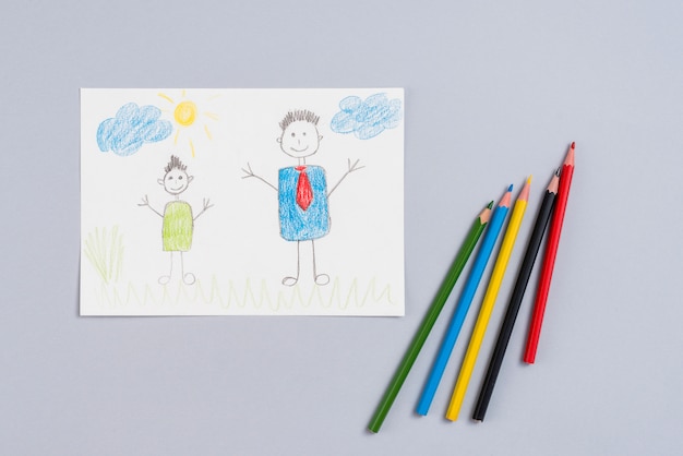 Photo dessin de père et fils sur papier avec des crayons