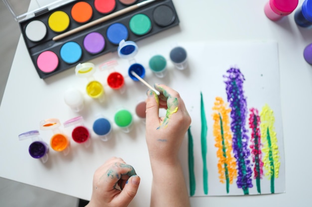 Dessin pour enfants avec des peintures vue de dessus mains avec des peintures