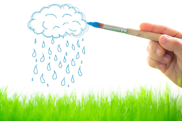 Dessiner des nuages et de la pluie sur l'herbe verte du printemps