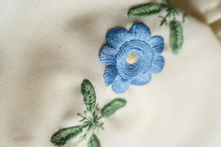 Photo des dessins floraux magnifiquement brodés sur un tissu présentant des couleurs vives et des détails complexes