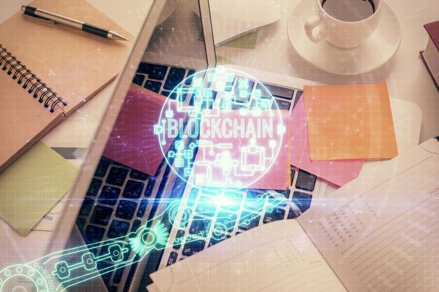 Dessins d'hologrammes sur le thème de la blockchain sur ordinateur sur fond d'écran Vue de dessus Concept d'exposition multiple de cryptoéconomie