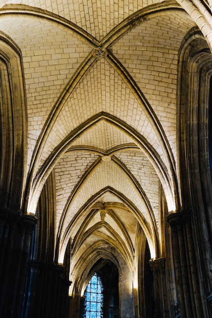 Photo de dessous de la majestueuse cathédrale catholique avec son haut plafond géométrique et ses grandes fenêtres photo