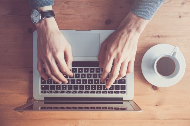 De dessus de la personne qui tape sur un ordinateur portable