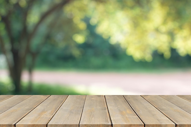 Dessus de table en bois et arbre flou et fond de feuille verte