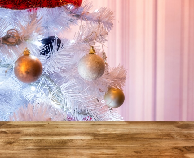 Dessus de table en bois sur l'éclairage blanc d'arbre de Noël avec la décoration de scintillement de boule