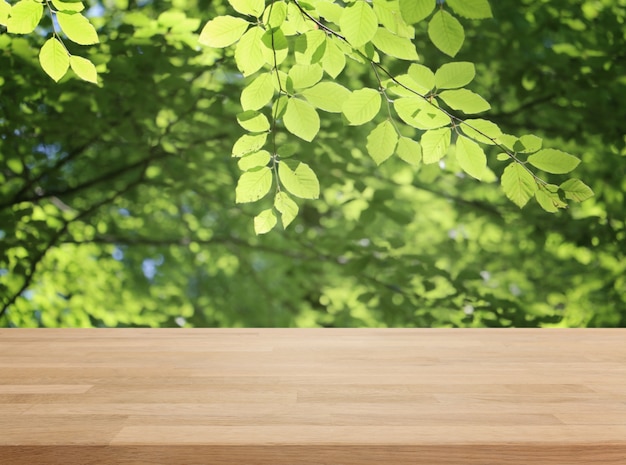 Dessus de table en bois et fond de feuille verte floue