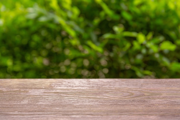 Dessus de table en bois sur fond de feuilles. Placement de votre produit