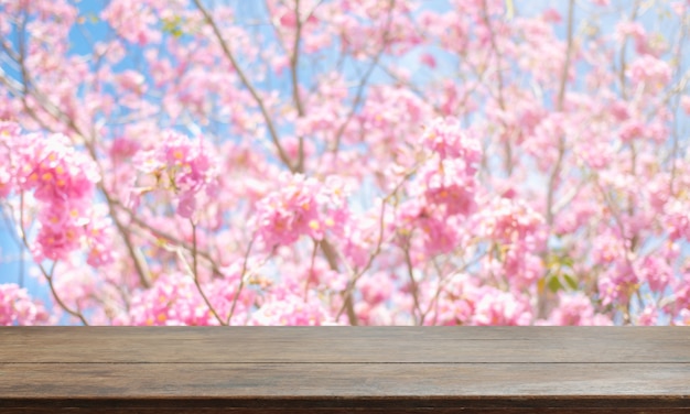 Dessus de table en bois et fond de fleurs floues avec filtre vintage