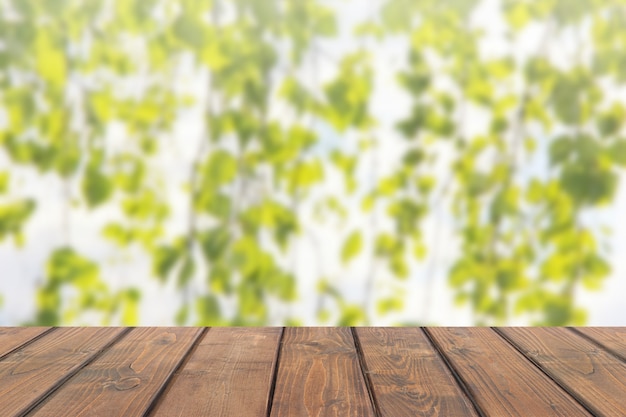 Dessus de table en bois sur fond flou abstrait avec des branches de bouleau