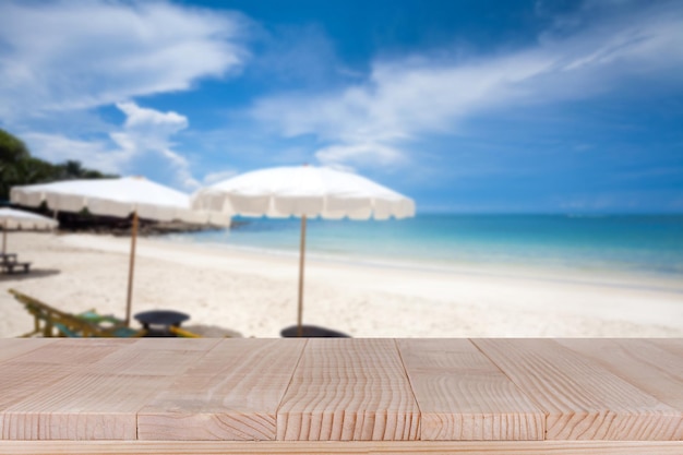 Photo dessus de table en bois sur fond de plage de sable blanc et mer bleue floue