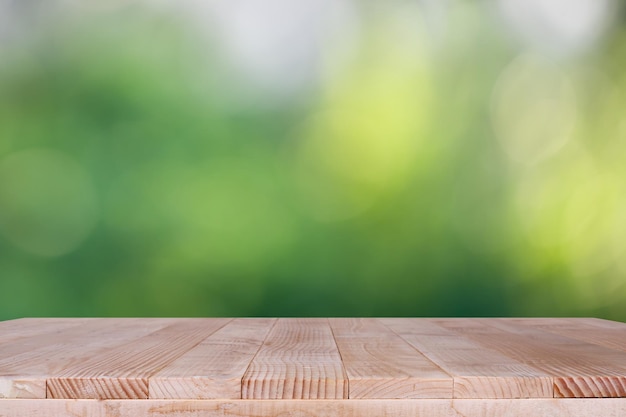 Le dessus de table en bois sur fond vert bokeh peut être utilisé pour le montage ou l'affichage de vos produits