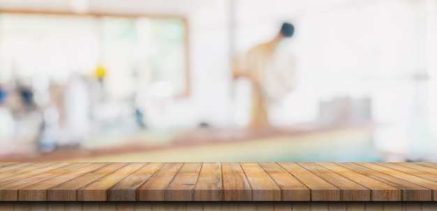 Dessus de table en bois avec des personnes floues dans un café et un fond de café pour l'espace de copie de montage d'affichage