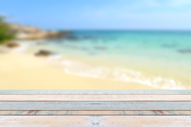 Dessus de table en bois avec scène de nature floue plage tropicale et ciel bleu, concept de fond de vacances - peut être utilisé pour l'affichage ou le montage de vos produits