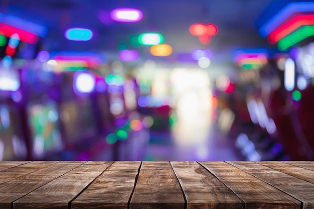 Photo dessus de table en bois vide sur abstrait flou magasin de centre de jeu et discothèque lumières fond.