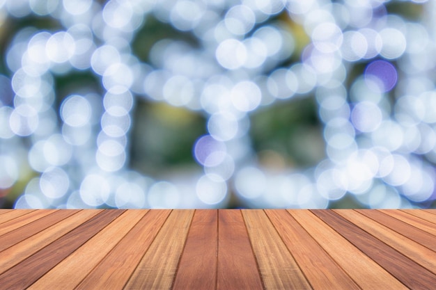 Dessus de table en bois vide avec arbre de Noël flou avec fond clair bokeh