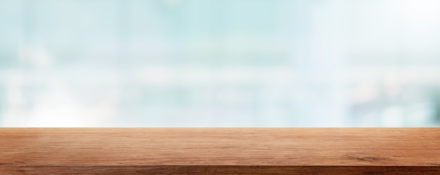 Dessus de table en bois vide et bâtiment de mur de fenêtre en verre flou