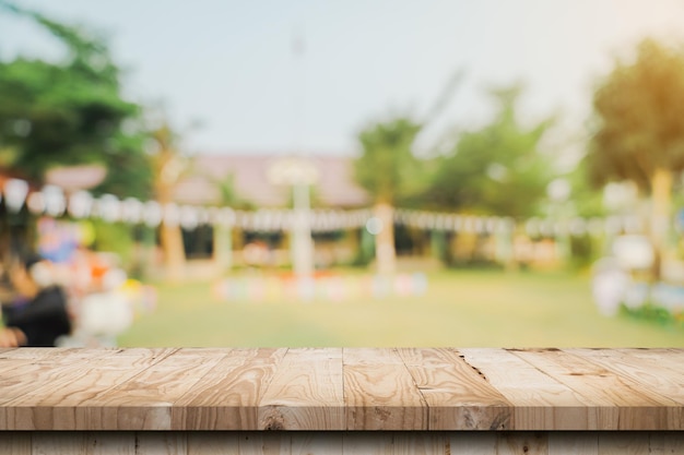 Dessus de table en bois vide et bokeh léger flou abstrait et arrière-plan flou des arbres de jardin dans le modèle d'affichage du produit de la lumière du soleil avec espace de copie