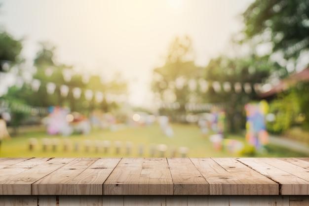 Dessus de table en bois vide et bokeh léger flou abstrait et arrière-plan flou des arbres de jardin dans le modèle d'affichage du produit de la lumière du soleil avec espace de copie