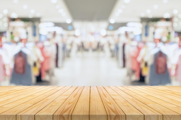 Dessus de table en bois vide avec boutique de vêtements flou afficher fond de centre commercial intérieur