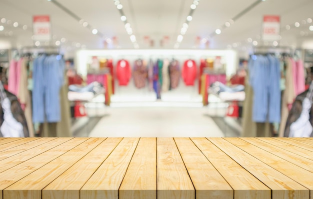 Dessus de table en bois vide avec boutique de vêtements flou afficher fond de centre commercial intérieur