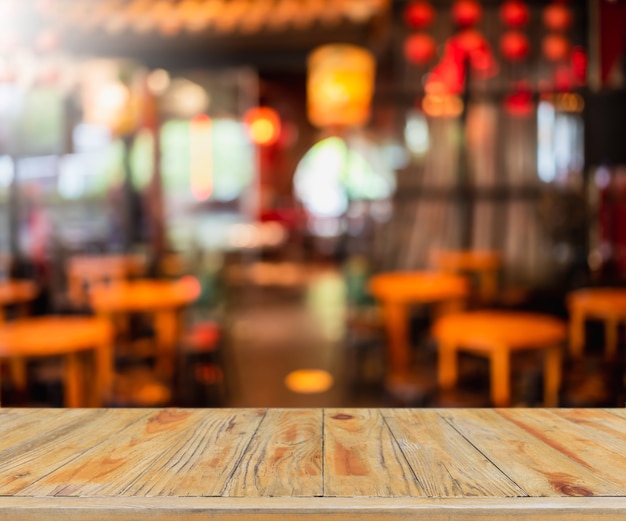 Dessus de table en bois vide et café floue et intérieur du restaurant