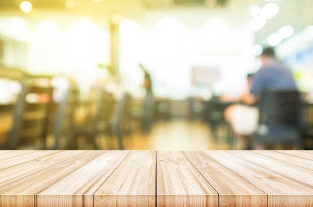 Dessus de table en bois vide avec fond intérieur café café floue.