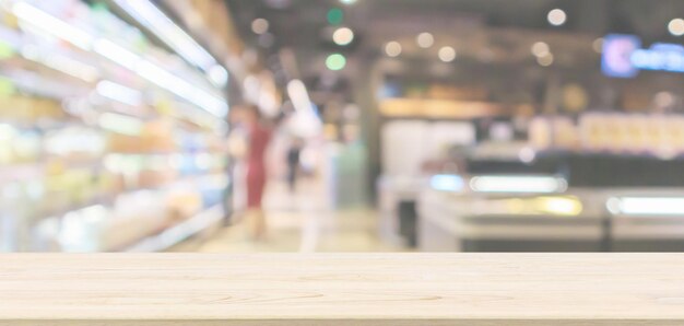 Dessus de table en bois vide avec intérieur abstrait de l'allée du supermarché floue arrière-plan défocalisé