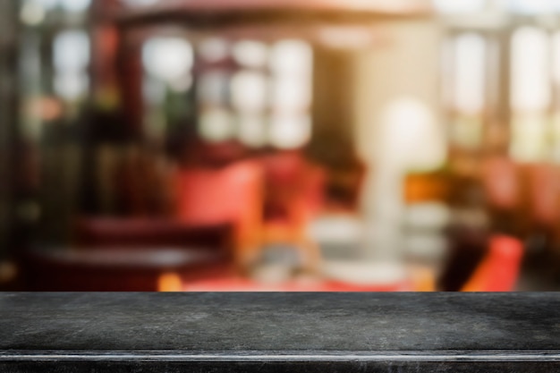 Dessus de table en pierre de marbre noir vide et fond de café et de restaurant flou.