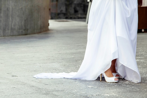 Détail d'une belle robe de mariée et de chaussures un jour de mariage et de riz dans le sol