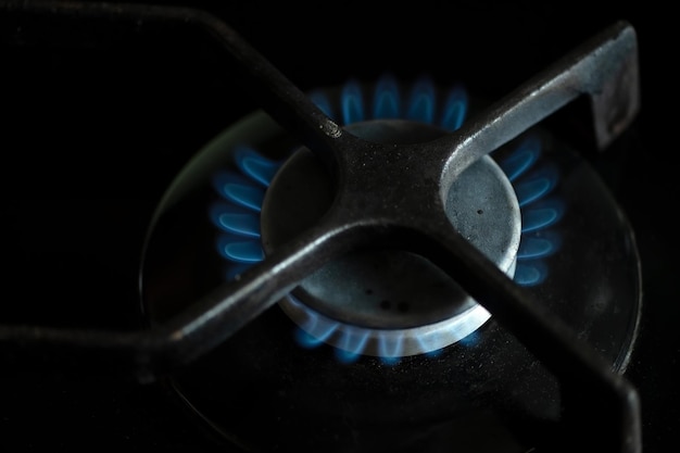 Détail de la combustion de gaz sur la cuisinière, hausse des prix du gaz, détail d'une cuisinière à gaz noire, croissance des prix