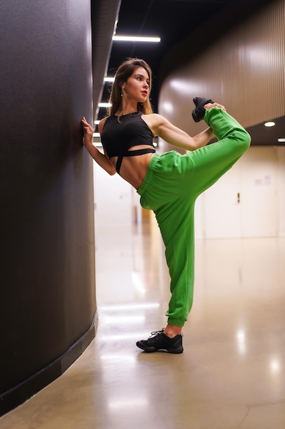 Détail d'une danseuse hiphop urbaine à l'intérieur d'un bâtiment des exercices d'étirement sur un mur