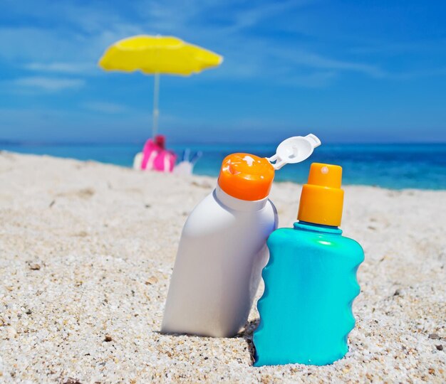 Détail de deux bouteilles de crème solaire sur le sable