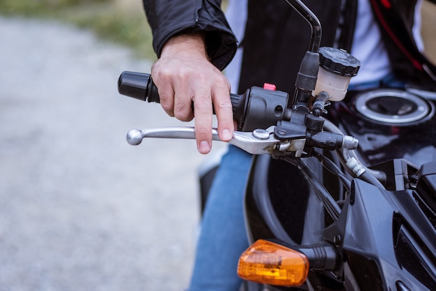 Détail du guidon d&#39;une moto avec le frein et la main du pilote