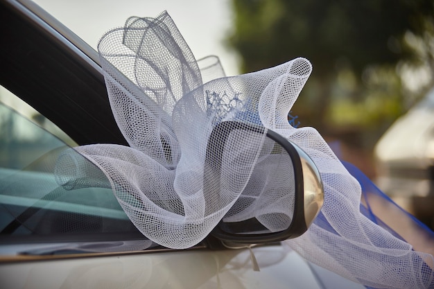 Détail du miroir d'une voiture orné d'un nœud pour le mariage