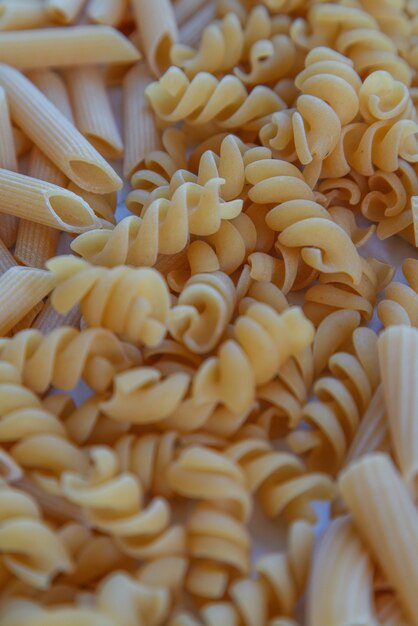 Photo détail en gros plan d'une poignée de pâtes en forme de spirale non cuites