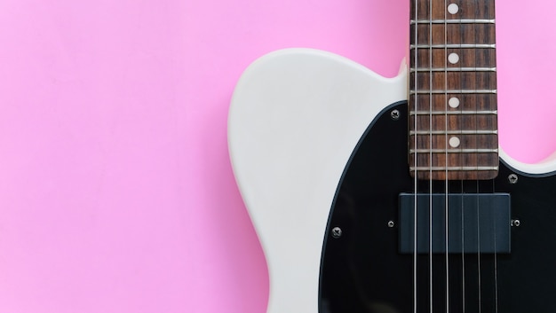 Détail de la guitare électrique sur un fond rose