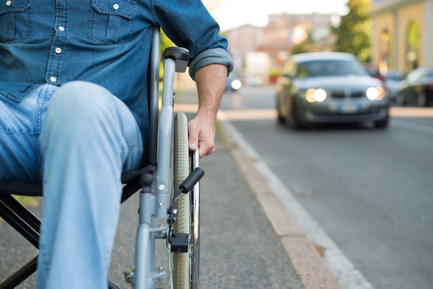 Détail d&#39;un homme en fauteuil roulant dans une rue urbaine