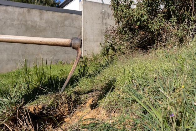 Détail d'une houe creusant le sol d'un jardin pour la plantation